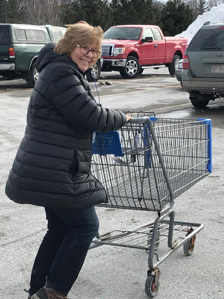 Employee returning a shopping cart to the store